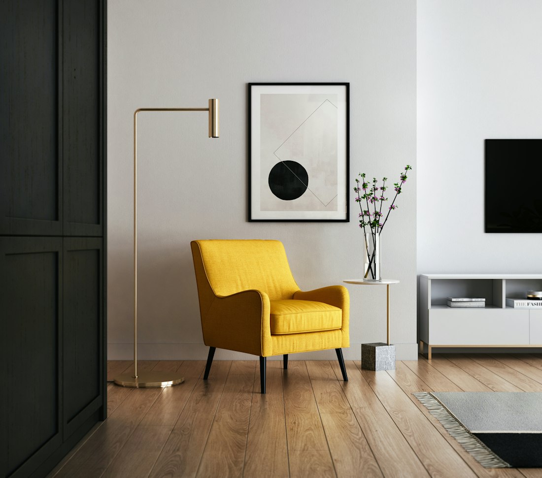 Warm, sunlit small living room with a comfortable armchair, wooden side table, and soft neutral tones